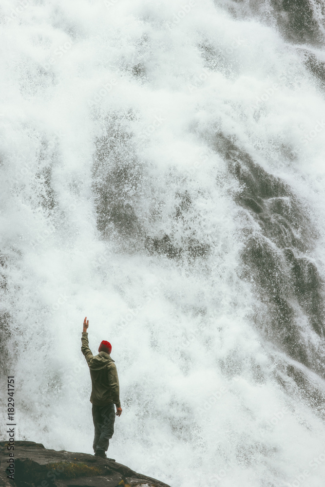 Happy Man standing on cliff at big waterfall outdoor Travel Lifestyle success concept adventure scandinavian vacations in Norway Happy Man standing on cliff at big waterfall outdoor Travel Lifestyle success concept adventure scandinavian vacations in Norway
