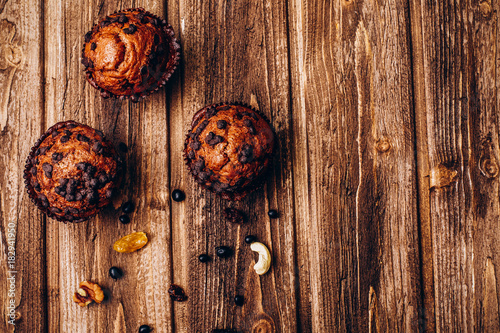 Delicious cupcakes with blackberries on wooden table