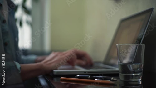 Business man using laptop at home. Sticky note with question sign on desk