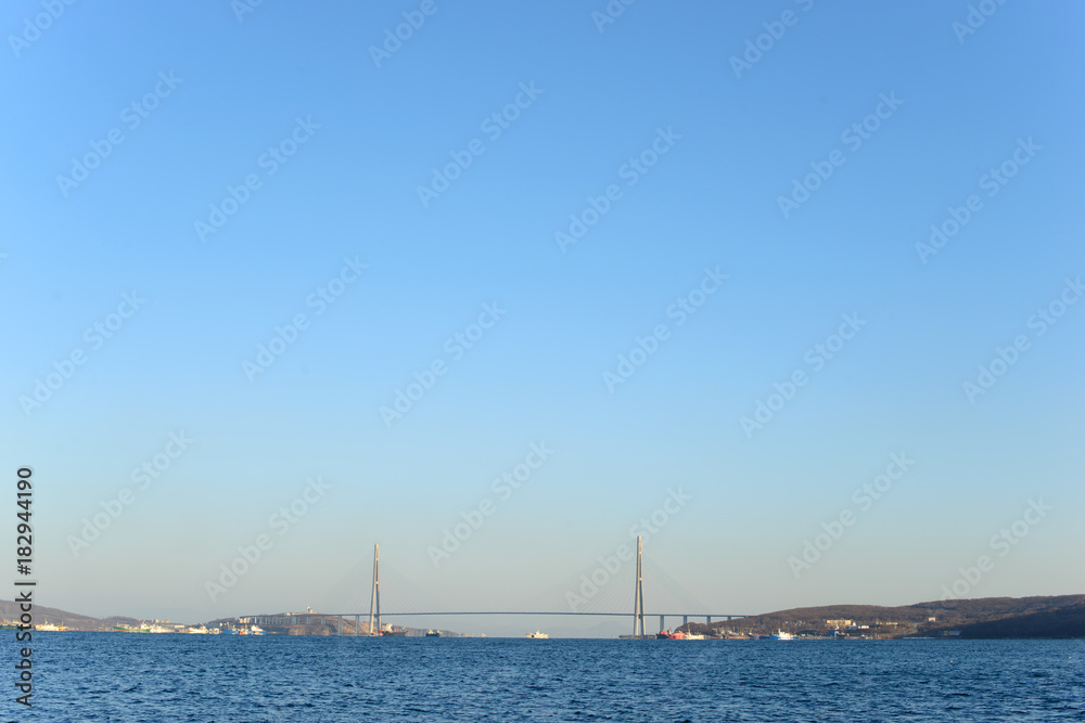 Distant suspension bridge over the sea background. Free copy space.