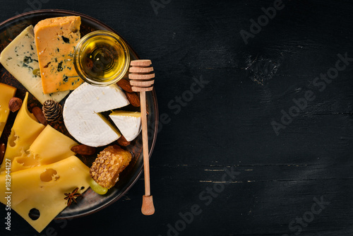 Grapes, red wine, cheeses, honey and nuts on a wooden background. Top view.