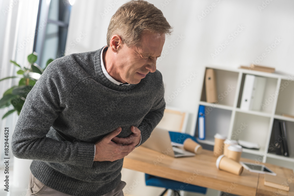middle aged man having heart attack in his office middle aged man having heart attack in his office