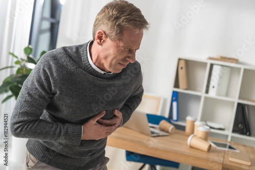 Tableau sur toile middle aged man having heart attack in his office