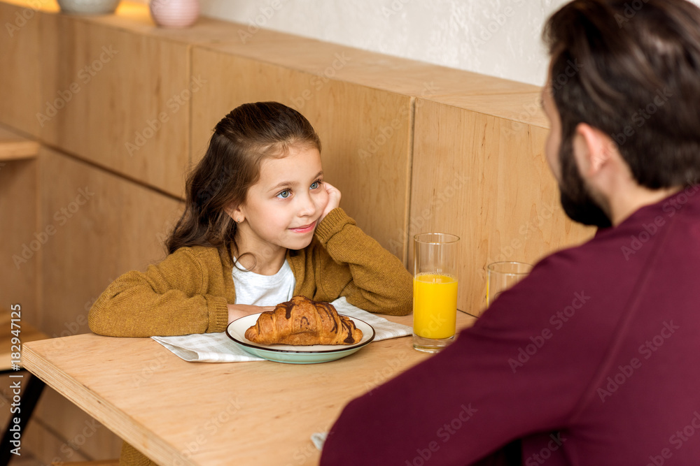 cropped image of daughter looking at father while sitting in cafe cropped image of daughter looking at father while sitting in cafe