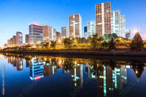 Business district office buildings and water reflection in Beijing at night
