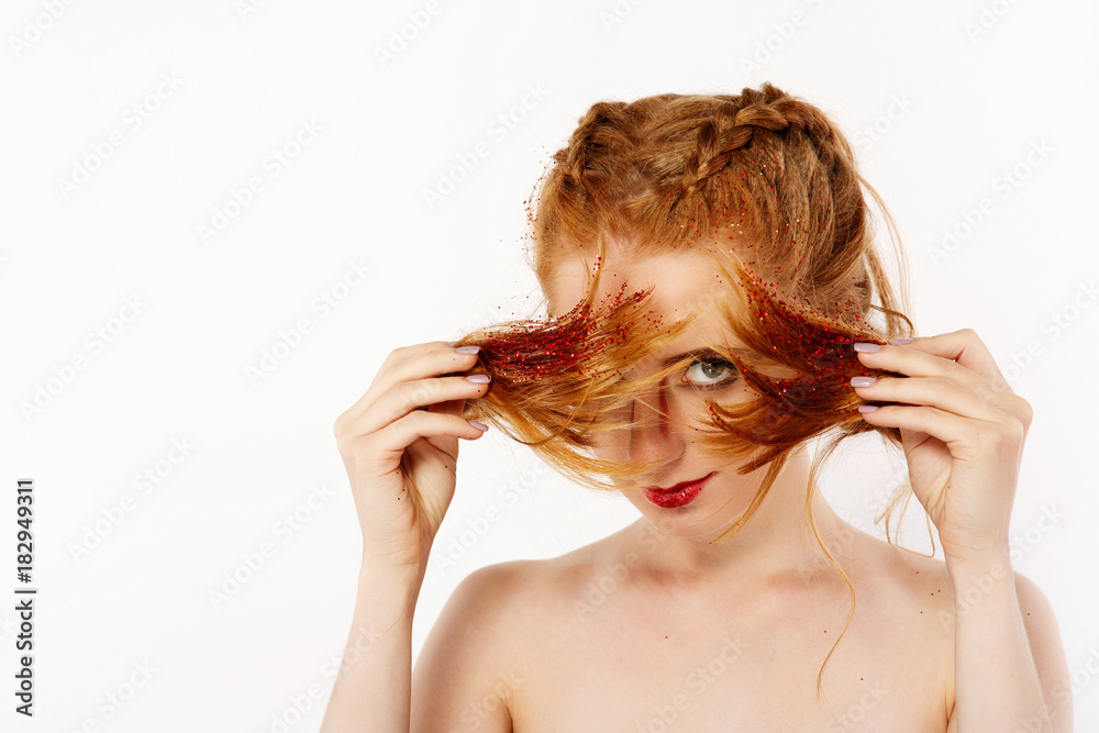 Naklejka premium Pretty girl with red hair looks like a lion posing in the studio