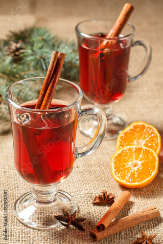 Glasses of Christmas mulled wine with spices and orange on sackcloth