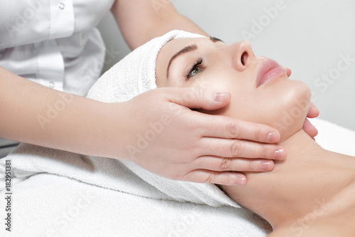 woman receiving facial massage at spa salon