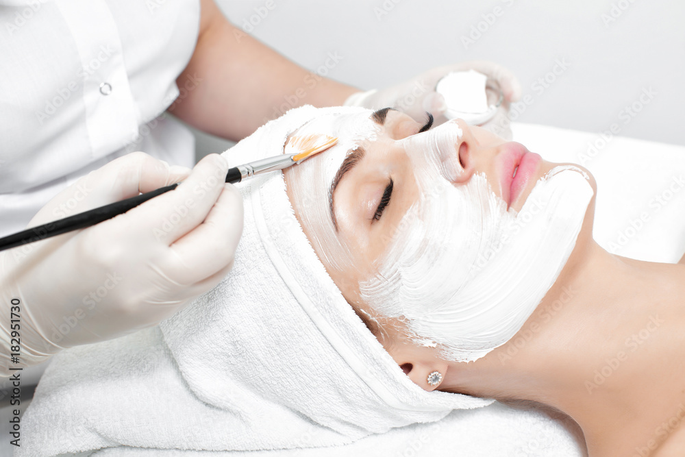 beautician applies mask to the face of  woman 