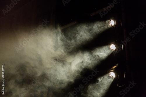The light rays from the spotlight through the smoke. Theater lighting equipment.