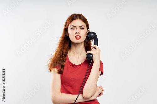 Beautiful young woman on a white background holds a fixed telephone  communication