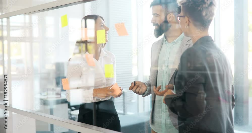 Picture of designers sticking notes in office Picture of designers sticking notes in office