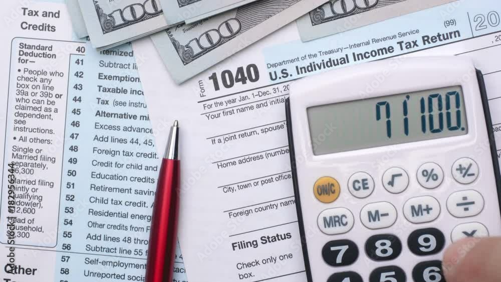 USA tax form 1040, pen, dollar bills, and calculator. High angle view.
USA tax form 1040, pen, dollar bills, and calculator. High angle view.