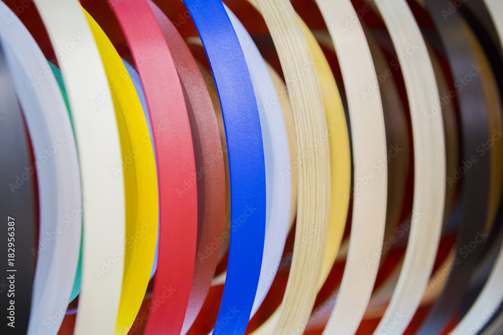 Foto de Solid color or wood grain PVC edge banding tape. ABS edge banding.  Set of colored thermoplastic edges. Multicolored bobbins of PVC edge and  melanin for the manufacture of furniture do