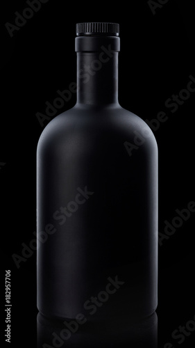 Black whiskey bottle on dark background