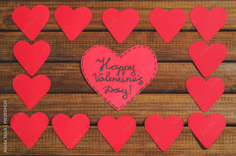 Cut out of red paper hearts on wooden background, congratulation with Valentine's day, top view