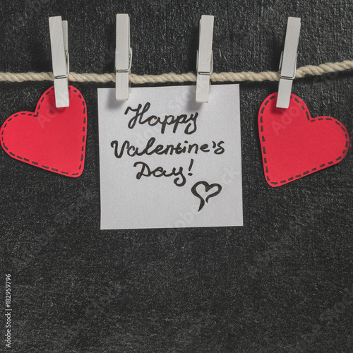 Cut out of red paper hearts hang on the rope on the little primako, greetings happy Valentine's day, top view photo