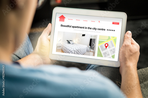 Fotografija Man search apartments and houses online with mobile device