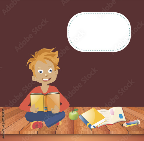 The boy is sitting and reads a book