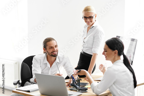 Team Working In Office, Looking At Computer