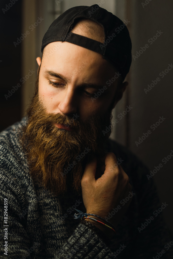 Bearded man in cap posing inside Bearded man in cap posing inside