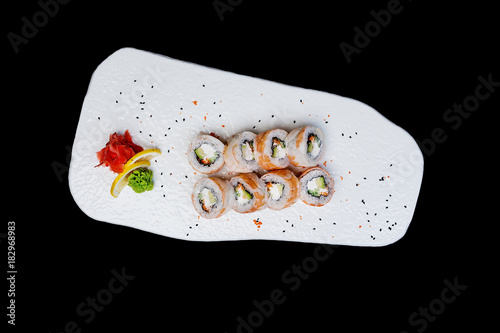 Philadelphia roll with a cucumber, avocado, some cream cheese, tobiko caviar and shrimp. Top view. Isolated on a black background photo