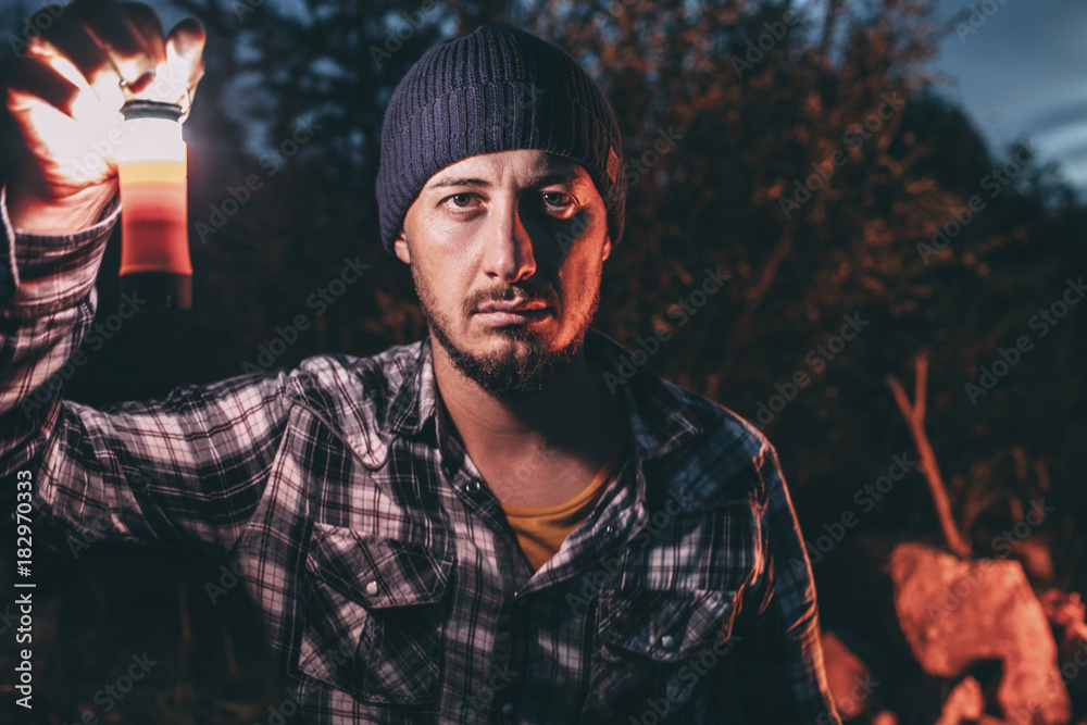 Portrait of serious man with lamp in rural landscape Portrait of serious man with lamp in rural landscape