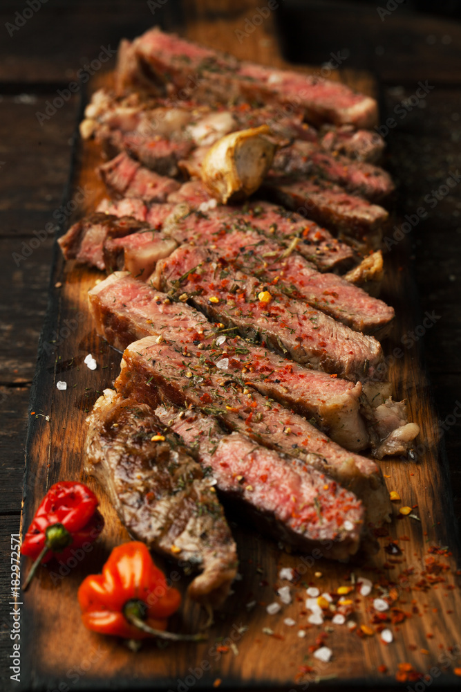 Sliced medium rare grilled  steak ribeye with salt, spices, and rosemary