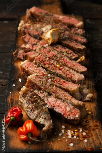 Sliced medium rare grilled  steak ribeye with salt, spices, and rosemary