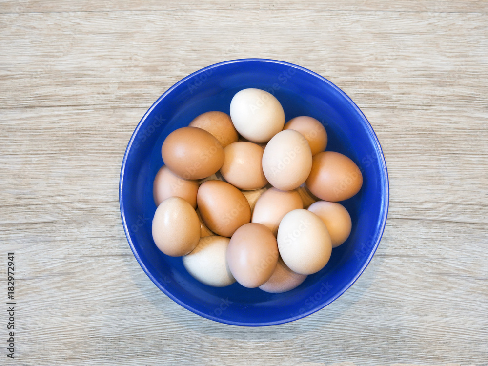 eggs in a plastic bowl on a wooden background eggs in a plastic bowl on a wooden background