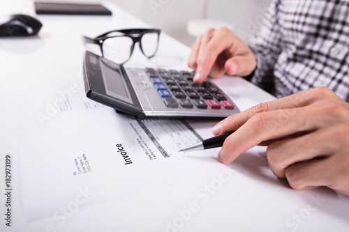 Businessman's Hands Calculating Invoice