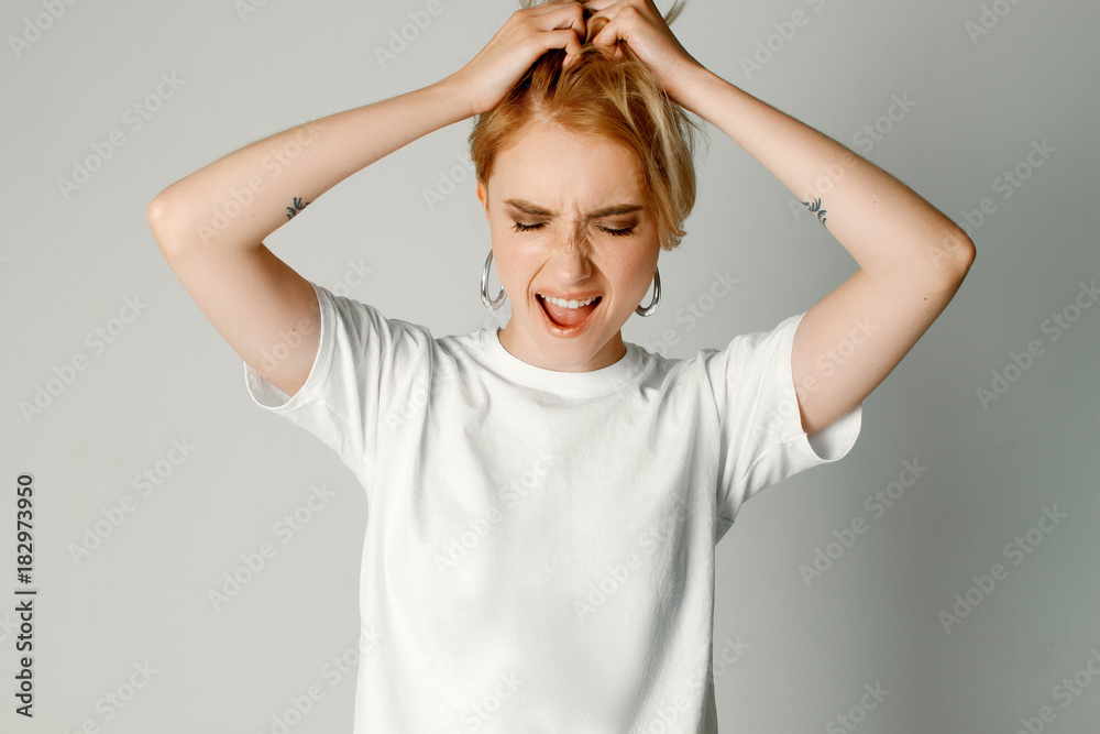Portraits of a beautiful girl with a short hairstyle on a white background in a white T-shirt Portraits of a beautiful girl with a short hairstyle on a white background in a white T-shirt