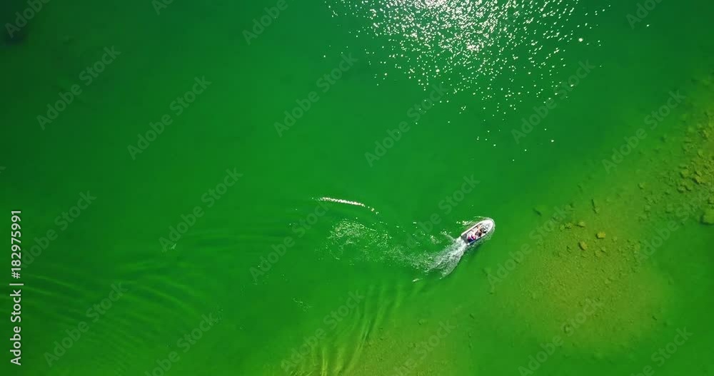 Recreational Watercraft With Wake Moving Slowly In Green Lake Water - Holland Lake, Montana Recreational Watercraft With Wake Moving Slowly In Green Lake Water - Holland Lake, Montana