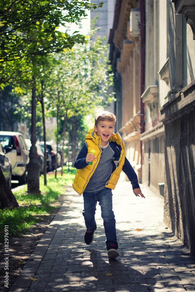 Playful boy running on the street.