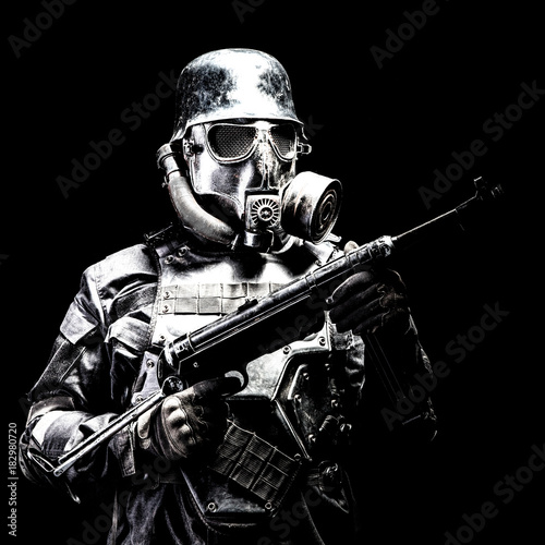 Futuristic nazi soldier gas mask and steel helmet with schmeisser handgun black background studio shot