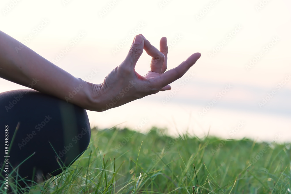 Close up of hand in a meditation pose . Woman exercising vital and meditation for fitness lifestyle in the beach sunset background. Healthy Concept.. Close up of hand in a meditation pose . Woman exercising vital and meditation for fitness lifestyle in the beach sunset background. Healthy Concept..