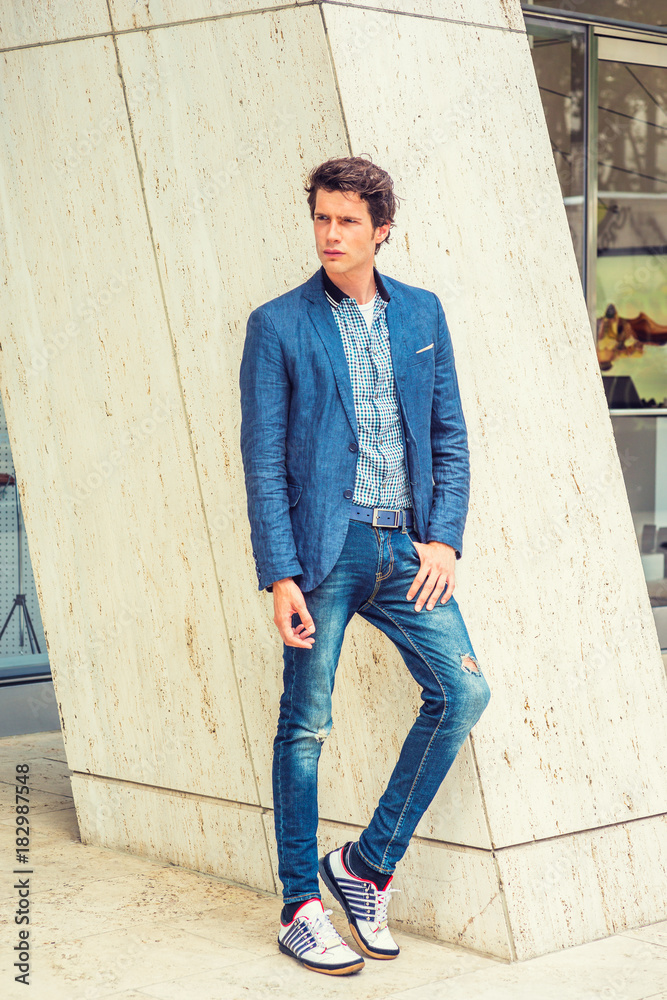 Man Casual Urban Fashion. Wearing blue blazer, patterned under shirt, jeans,  fashionable sneakers, a young European guy standing by column, waiting for  you to shopping outside store. . Stock 写真 | Adobe Stock