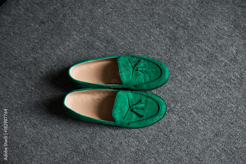 Green man’s shoes on a grey floor