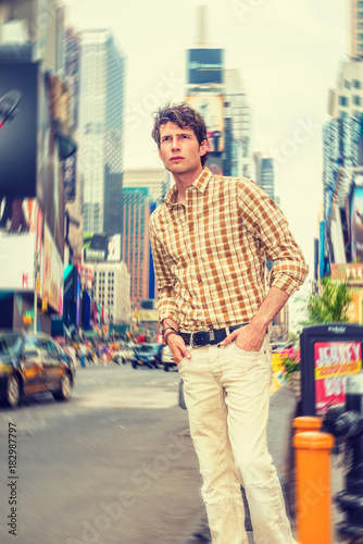Radial blur background of Times Square, a young European guy traveling in New York, wearing yellow patterned shirt, pants, standing on busy street, looking around, watching, thinking. .