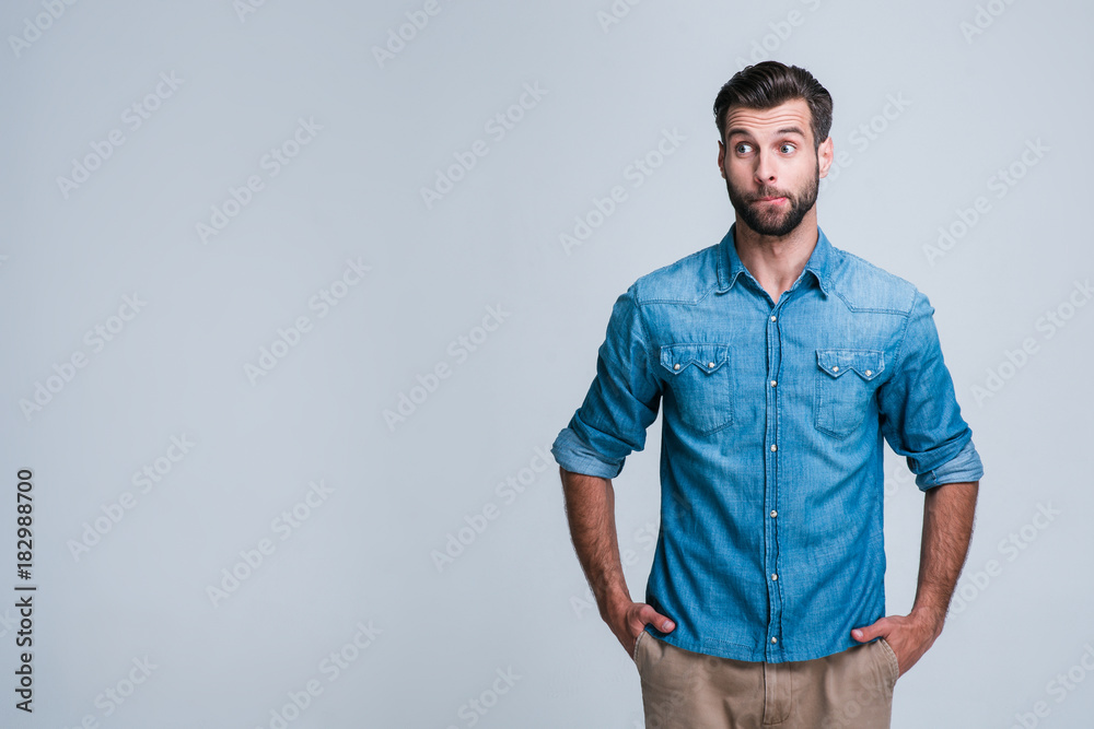 Maybe I do something wrong? Handsome young man looking confused while standing against white background Maybe I do something wrong? Handsome young man looking confused while standing against white background