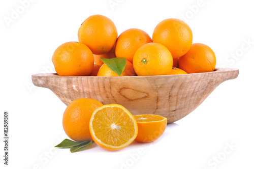 orange in wooden bowl and sliced orange on wite background 