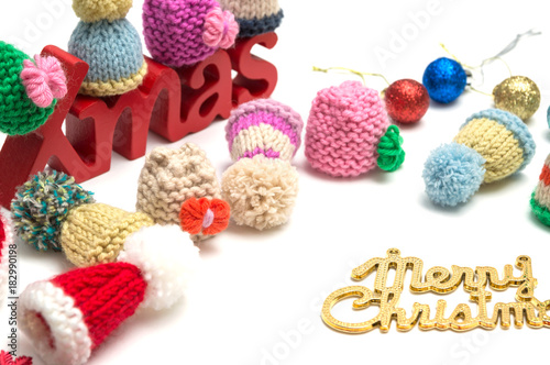 X-mas and merry christmas text, ball, fur hat, red snow flower decoration on white background