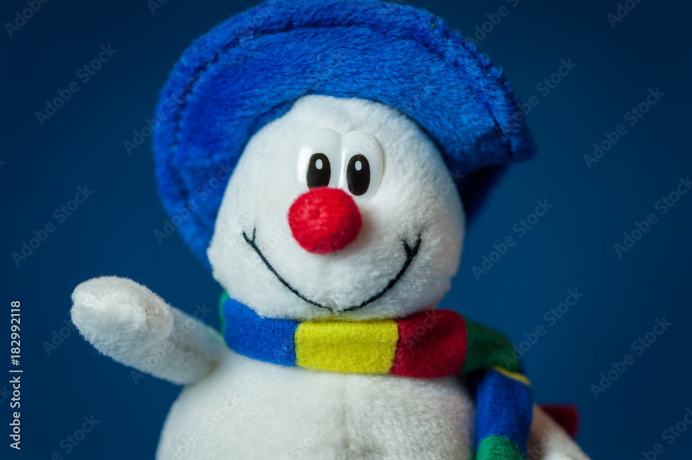A cute little soft snowman with a blue hat and a colorful scarf A cute little soft snowman with a blue hat and a colorful scarf