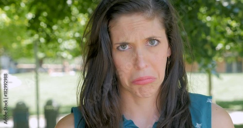 Sad unhappy upset woman pouting and frowning and looking at camera