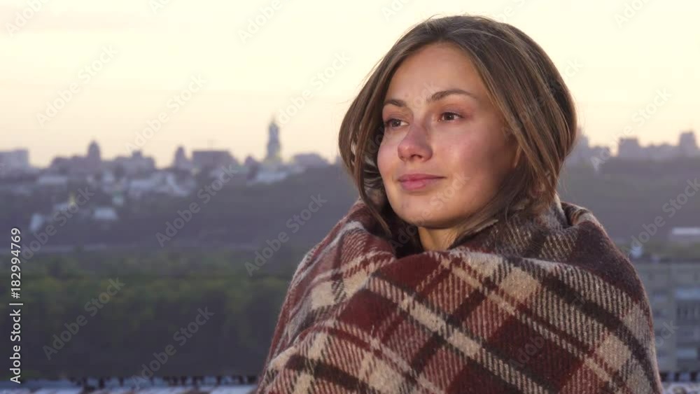 Wrapped in a blanket the girl enjoys the sunset Wrapped in a blanket the girl enjoys the sunset