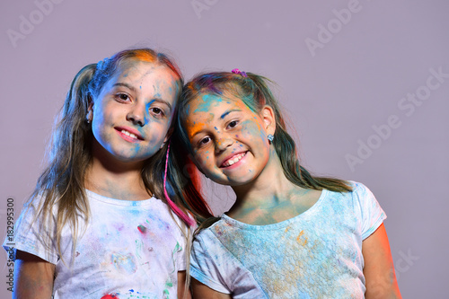 Schoolgirls have paint spots on faces and Tshirts.