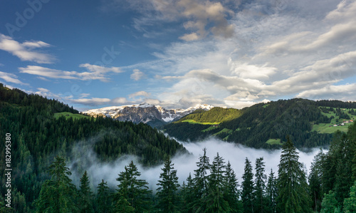 Fototapeta Naklejka Na Ścianę i Meble -  moorig in the Italian Dolomites near Alta Badia with forest and clouds in the valley and beautiful mountains behind