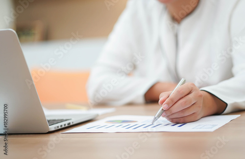 close up manager employee woman hand pointing on profits paper for thinking or writing somethings