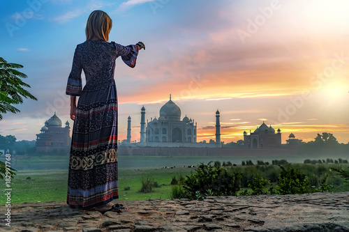 Beautiful girl points to Taj Mahal. Travel concept photo