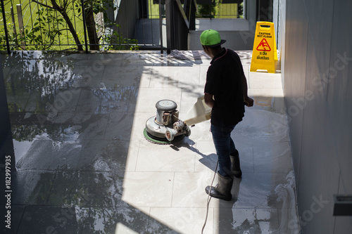 The man cleaning floor with machine. photo